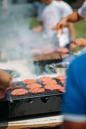 Burgers on a grill smoking. Outdoor summer barbequeの写真素材