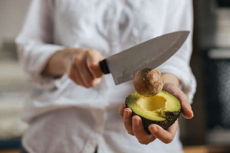 Female chef cutting avocado in a home kitchen