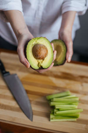 Female chef cutting avocado in a home kitchen