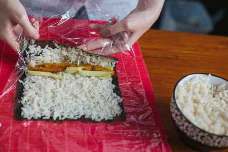 Female chef preparing sushi in the kitchenの写真素材