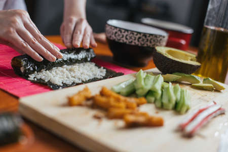 Female chef preparing sushi in the kitchenの写真素材
