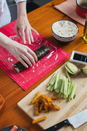 Female chef preparing sushi in the kitchenの写真素材