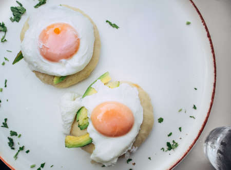 Vegetarian eggs benedict with avocado served on a steamed asian bao bun
