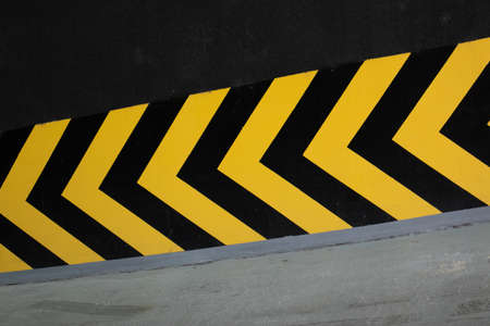Yellow and black arrows pointing toward basement parking garageの写真素材