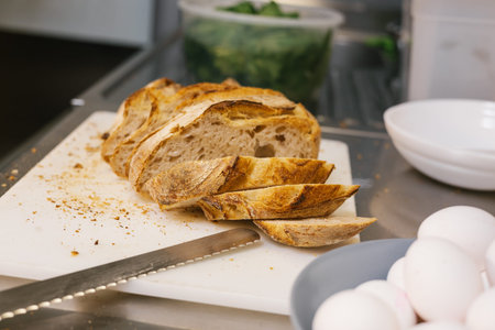 Slicing fresh artisan sourdough bread with eggs