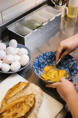 Person preparing fresh eggs for breakfast in kitchen