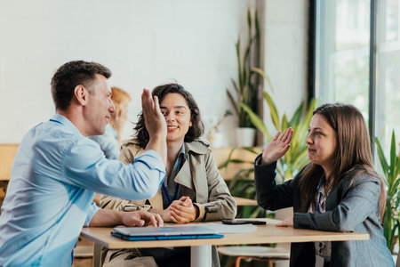 Coworkers high-fiving celebrating success and teamwork in office