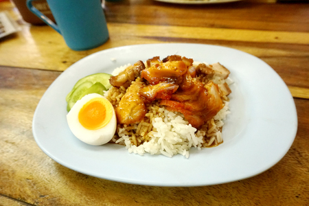 Close up barbecued pork, pork belly and half boil egg on top with chinese gravy sauce serve with jasmine rice.の写真素材