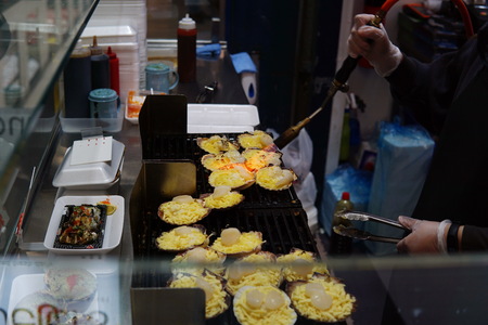 Image of staff grilling fresh scallop with cheese on top. Scallop prepare for eating by grill with cheese at seafood store.の写真素材