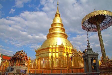 Golden pagoda on backdrop with cloud at Wat Phra That Hariphunchai , Lamphun Province, of Thailand の写真素材