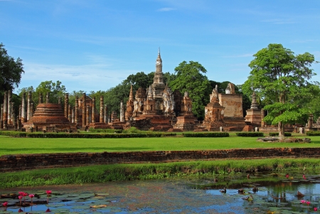 Field green grass and architecture of Wat Pra Mahathat in Sukhothai Historical park, Thailand の写真素材