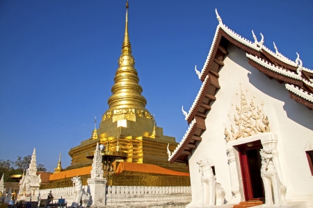 White church and gold pagoda blue  sky at Wat Phra That Chae Haeng, Nan province, Thailandの写真素材