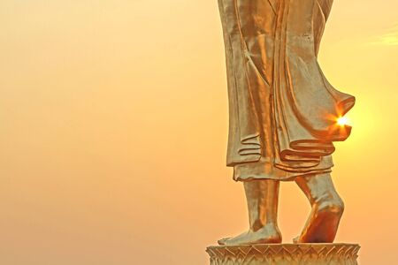 Beautiful sunshine and golden sculpture leg Buddha walk  at countryside of Nan, Thailandの写真素材
