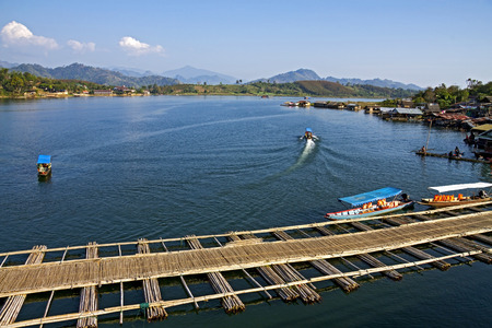 Bamboo bridge float and small boat in Sangklaburi Kanchanaburi country, Thailand の写真素材