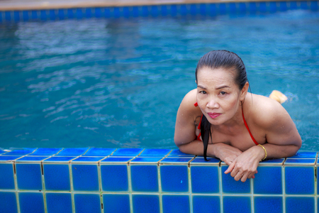 Woman happy relax with red bikini at swimming pool on beach at Bang Boet  beach, Prachuap Khirikhan Province Thailandの写真素材