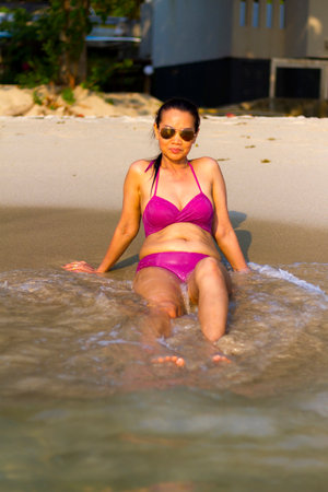 Woman sexy in bikini happy with wave on beach at beach Koh Chang Thailand.の写真素材