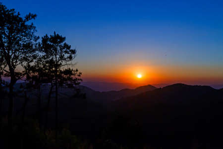 Sunset evening with silhouette mountain on countryside Taksin National Park Thailand.