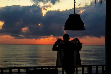 Woman in swimsuit and silhouette sunrise in morning on beach; in Prachuap Khiri Khan Province Thailand is famous for travel.の写真素材