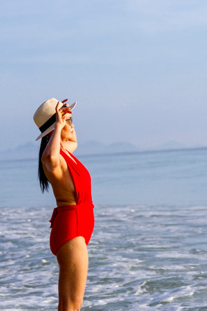 Woman with red swimsuit relax on beach Ban Krut Beach, in Prachuap Khiri Khan Province Thailand is famous for travel.の写真素材