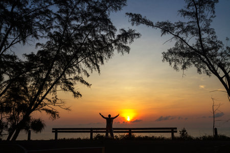 Sunrise and traveler with silhouette of pine at beach in Prachuap Khiri Khan Province in Thailand.の写真素材