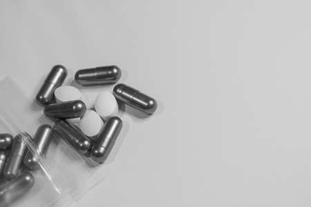 Monochrome immage of many pills on the table.の写真素材