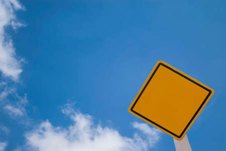 yellow warning board in bright skyの写真素材