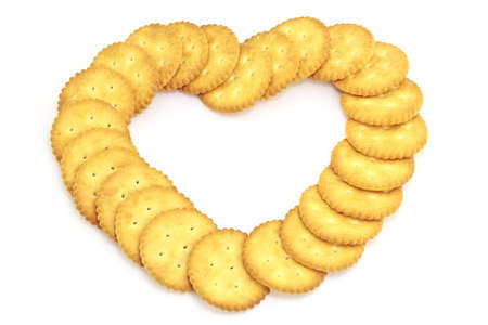 Biscuit arranged in a heart shape on white backgroundの写真素材