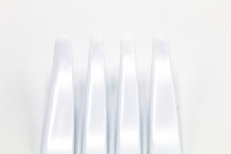 Cost-up plastic spoon and fork isolated on white background. It copy space and selection focus.の写真素材