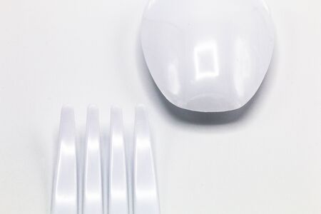 Cost-up plastic spoon and fork isolated on white background. It copy space and selection focus.