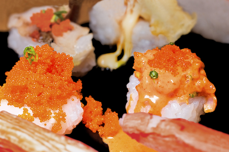 Sushi set sashimi and sushi rolls served on black stone slate. Close Up.の写真素材