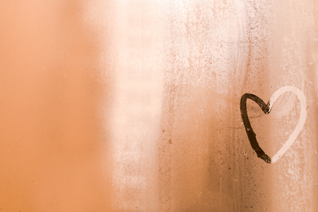 Rain drop in window and  inscription on the sweaty glass -love and heart.Copy space.Pastel tone.の写真素材