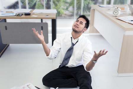 Portrait of tired and bored man 20-30 years.Yong businessman stressed and overworked  in office.He in white shirt and black plant.Copy space.の写真素材