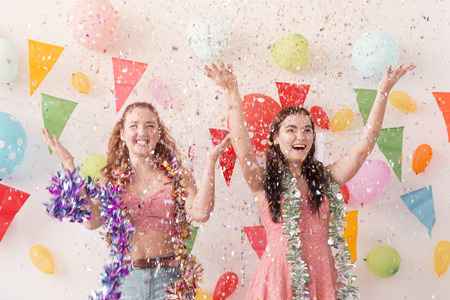 Young beautiful women celebrate holiday party and dancing.Best friends wearing dress,casual shorts and T-shirt,having fun in holiday.Pastel tone.の写真素材
