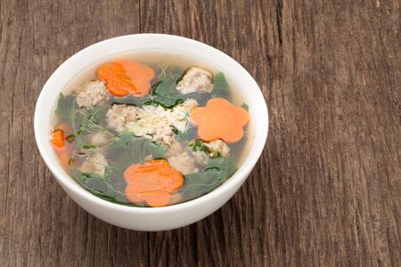soup with pork and gourd on wooden background and wooden spoonの写真素材