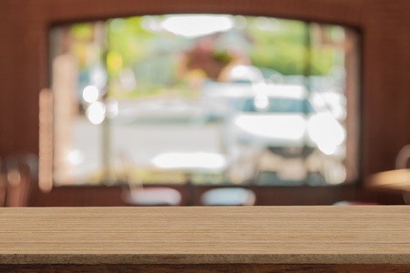 Perspective wooden table on top over blur coffee shop background, can be used mock up for montage products display or design layout.の写真素材