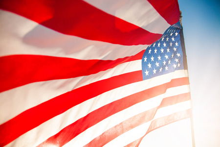 American flag with blue sky and sunlight for Memorial Day or 4th of July.