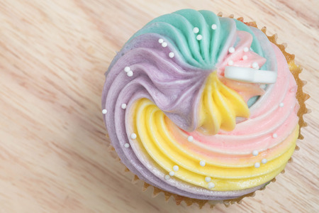 Colorfull Cream cheese Cupcakes In Tray On Wooden Table.