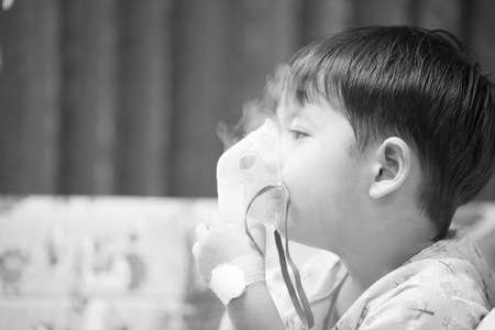 little boy wearing oxygen mask in hospital ward, black and white pictureの写真素材