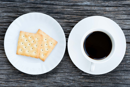 Cup of coffee and biscuit on wooden tableの写真素材