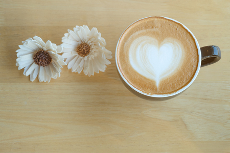 Latte art coffee in the morning time with sunlight on table wooden background.の写真素材