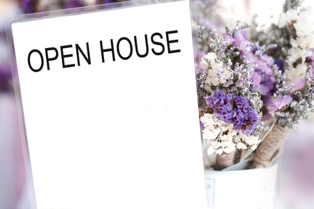 Open house word on card and purple flower background.