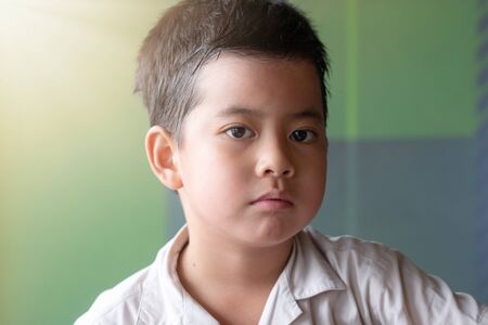 Close up asian boy showing feeling, isolated on blur background.の写真素材