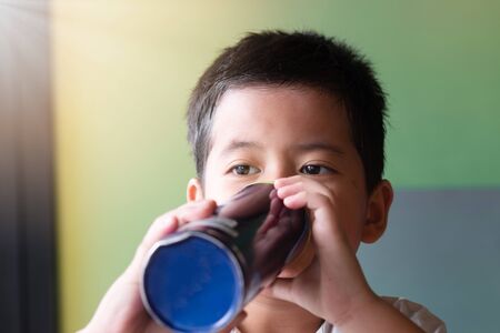 Asian boys drinking water from the water bottle. The concept of reducing the use of plastic. World Environment Dayの写真素材