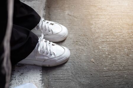 White sneakers on asphalt and sunlight in morning time.の写真素材