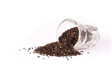 Close up organic black sesame seeds in glass on white background. Health food concept.の写真素材
