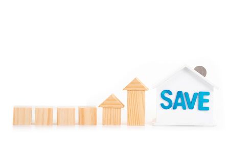 Empty wooden blocks and save word on house is white Piggy bank with coins on white background.Time to invest, real estate and property concept. Finance saving and investment concept.の写真素材