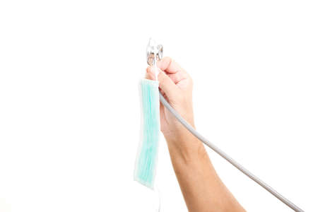 Doctor hands holding stethoscope and anti-virus mask on white background. Concept anti-virus protection Coronavirus, COVID-19 and other viruses.の写真素材