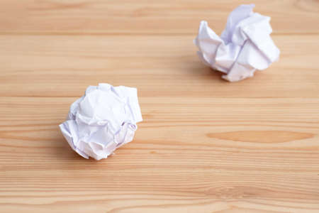 Close-up of crumpled paper ball,  white wadded paper on wooden background.の写真素材