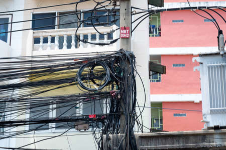 Messy electrical cables in thailand - many lines of cables chaotic set of interwoven, optical fiber technology open air outdoors.の写真素材
