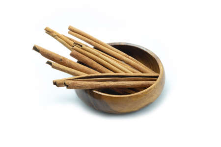 Cinnamon sticks in wooden bowl on white background.の写真素材